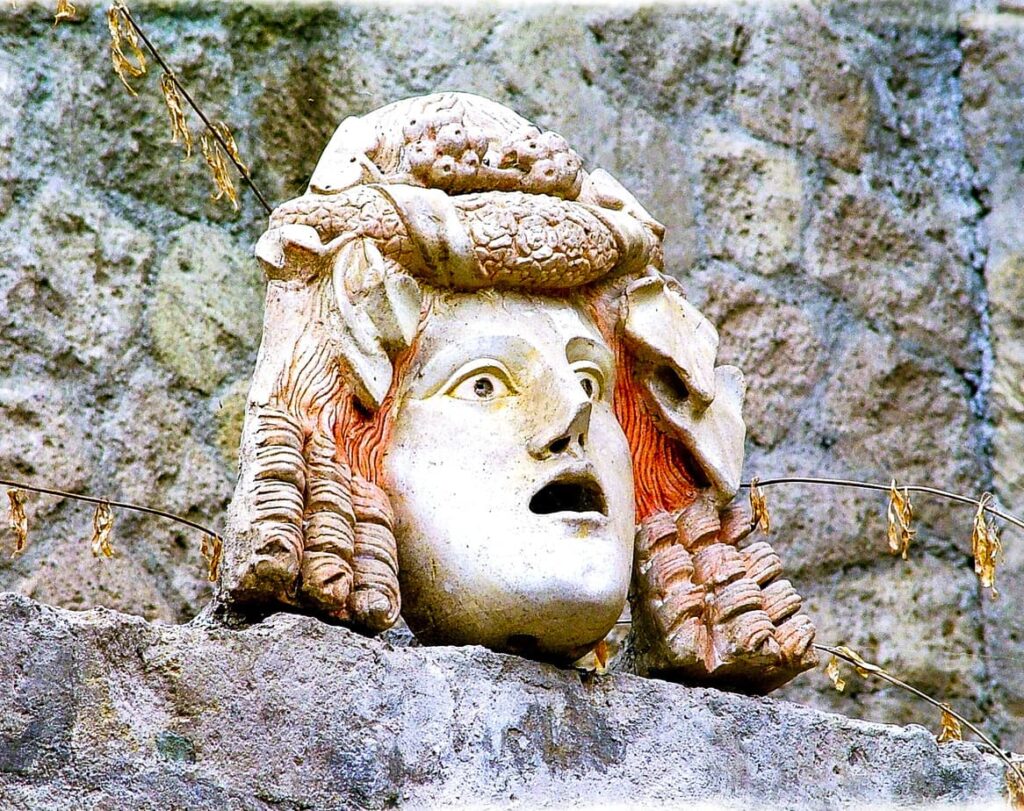 Stone theatrical mask sculpture at the Herculaneum archaeological site in Italy