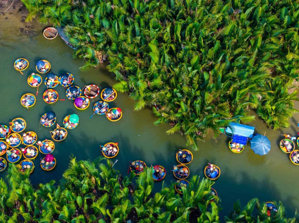 Aerial view of a coconut village basket boat tour. Palms forest in Hoi An ancient town, Cam Thanh, Vietnam. Tourists having an excursion and fun in Thu Bon river. Travel and landscape concept