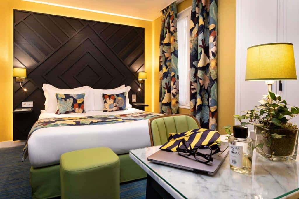 Bright boutique hotel bedroom at Hôtel des Arts Montmartre in Montmartre, Paris, with simple decor, neutral tones, and a small double bed