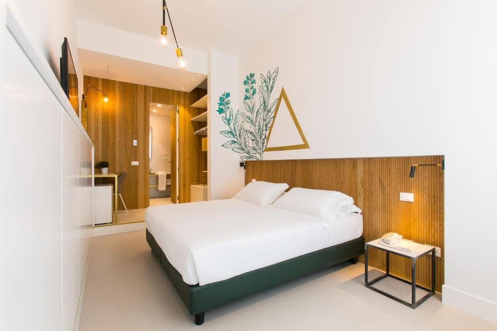 Minimalist modern room at Horti 14 Borgo Trastevere Hotel Rome featuring clean lines, botanical mural, and warm wooden accents.