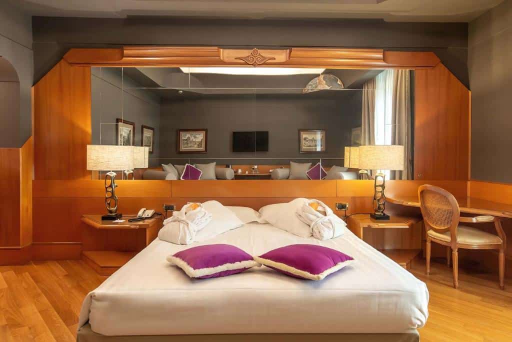 Modern double room at Hotel Isa in Rome’s Prati district with warm wood tones, statement lighting, and a cosy, contemporary feel.
