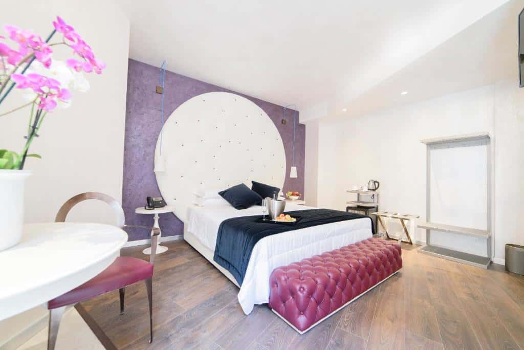 Elegant room at Hotel Vespasiano near the Vatican with purple accents, circular headboard, and fresh modern décor.