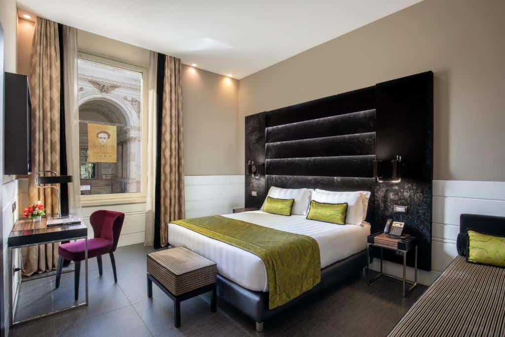 Stylish room at The Glam Hotel Roma featuring bold green accents, plush velvet headboard, and a view of Via Nazionale.