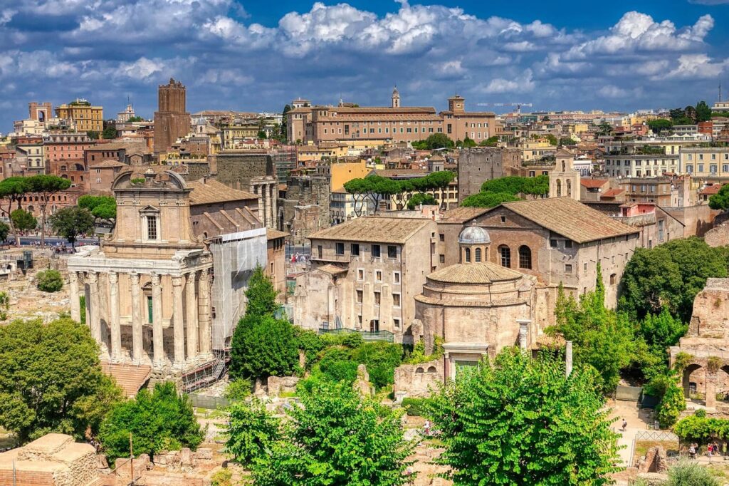 Ancient ruins of the Roman Forum in Rome, Italy, with columns, temples, and pathways bathed in golden afternoon light.