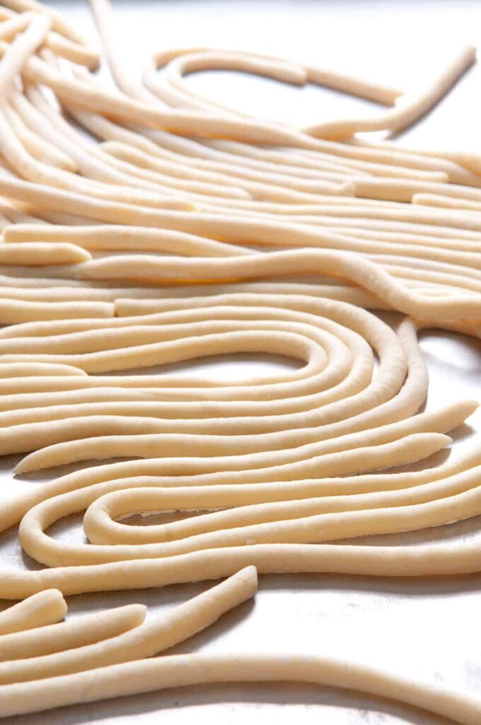 a tray of hand rolled pci pasta made from scratch