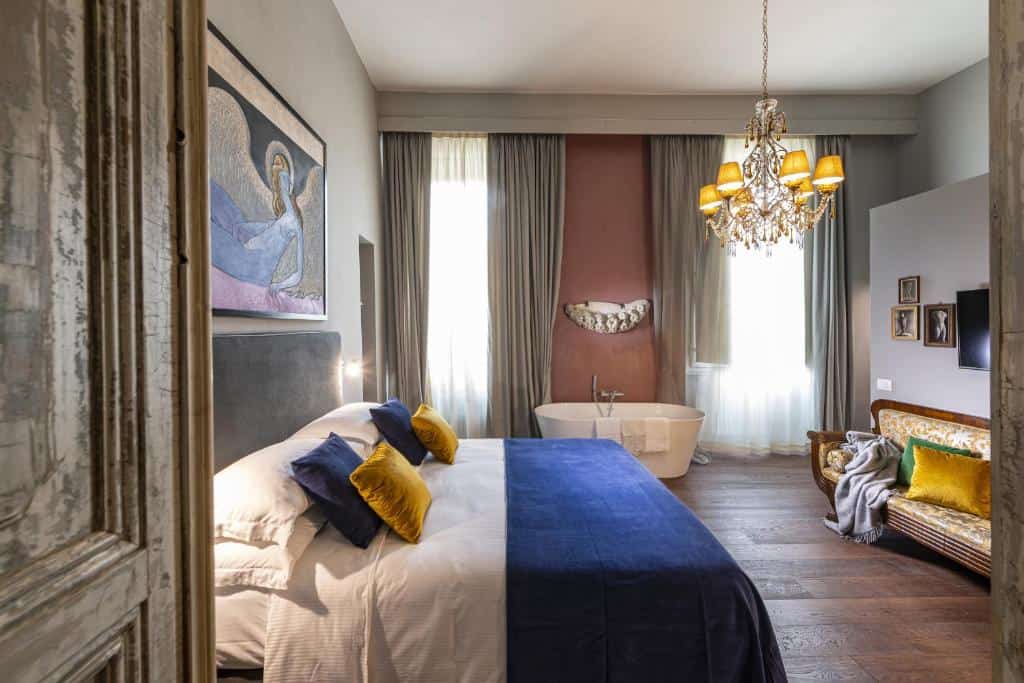 Elegant bedroom with freestanding bathtub and chandelier at Casa Botticelli boutique hotel in Oltrarno, Florence.