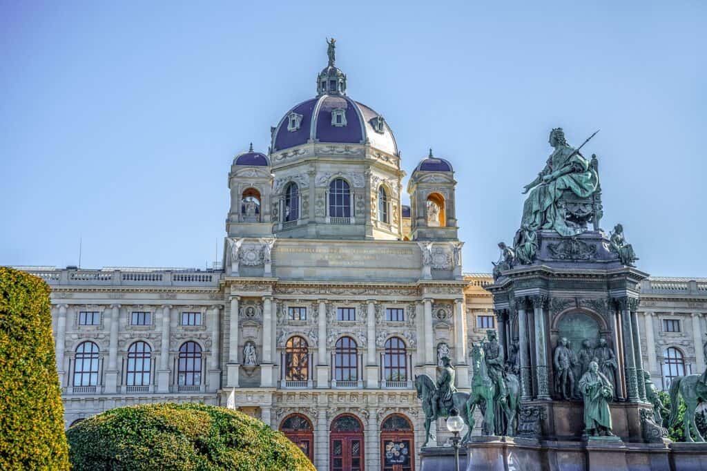 : Exterior of the Kunsthistorisches Museum in Vienna, Austria, with its domed roof and grand façade under a blue sky.