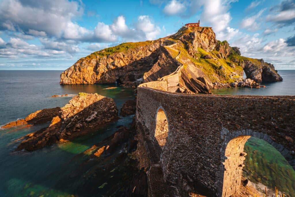 Panoramic view of Gaztelugatxe islet in the Basque Country, Spain, with stone bridge winding up to the hermitage on top of the island