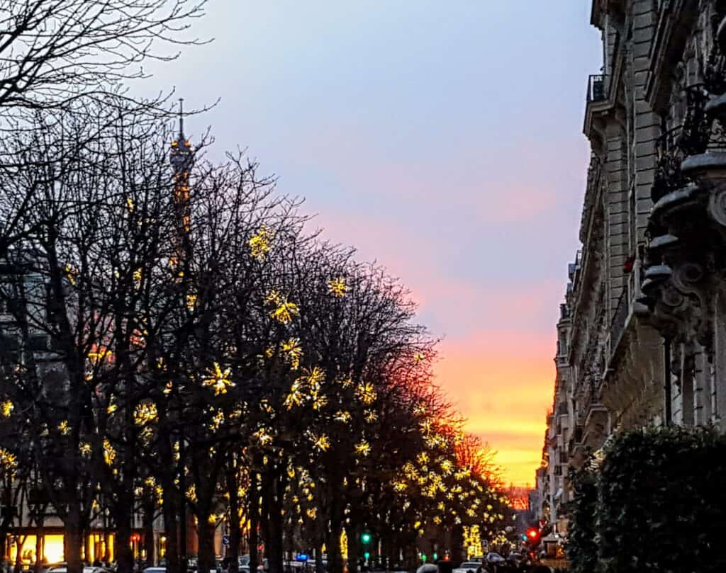 Christmas lights in Paris with the Eiffel Tower at sunset