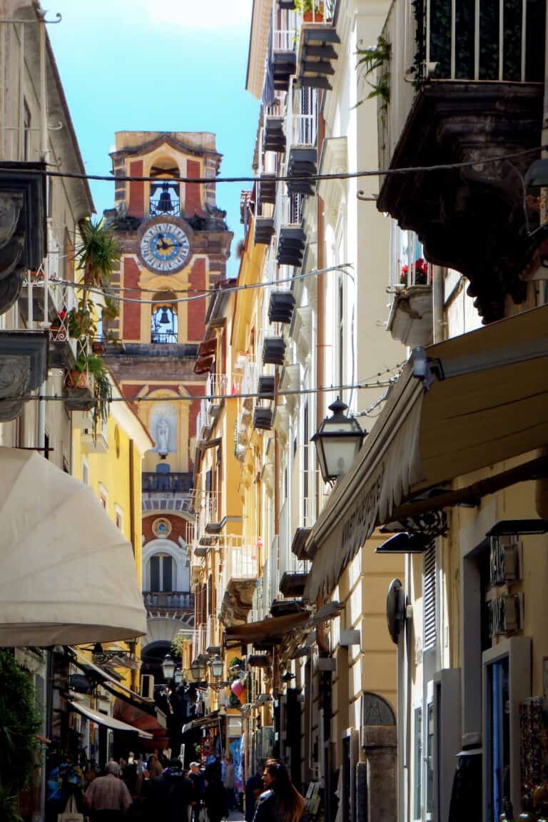Sorrento Old Town street with narrow lanes, balconies, shops, and a church bell tower