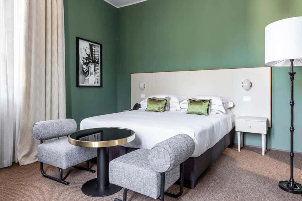 Modern bedroom with green walls and minimalist design at 4F Boutique Hotel Florence in Oltrarno.