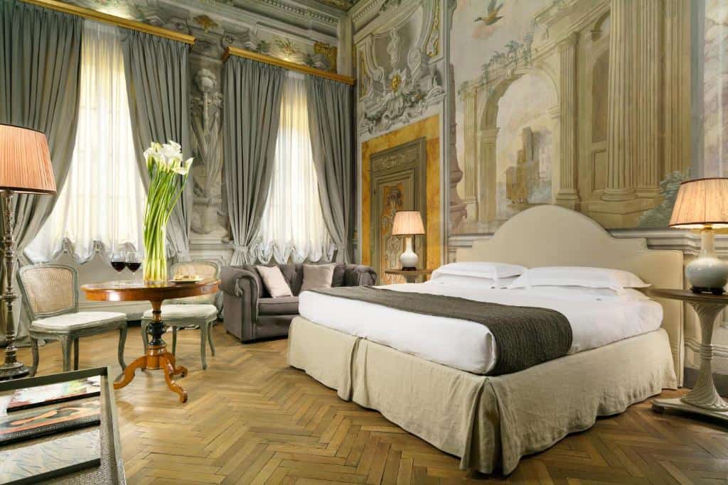 Luxury bedroom with frescoed walls and antique furniture at Al Palazzo del Marchese di Camugliano in Florence.