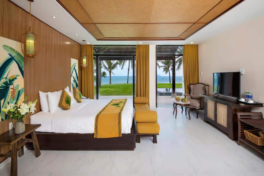 Beachfront hotel room with balcony overlooking tropical gardens at Palm Garden Hoi An.