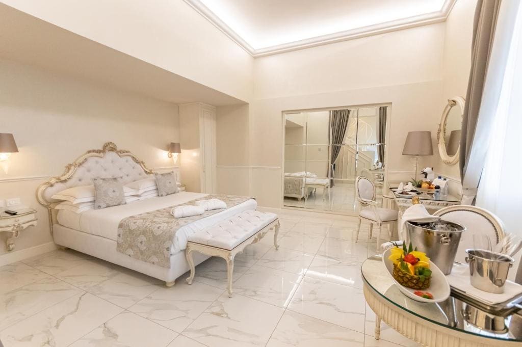 Luxury bedroom with marble floors and ornate furniture at The Moon Boutique Hotel & Spa in Florence.