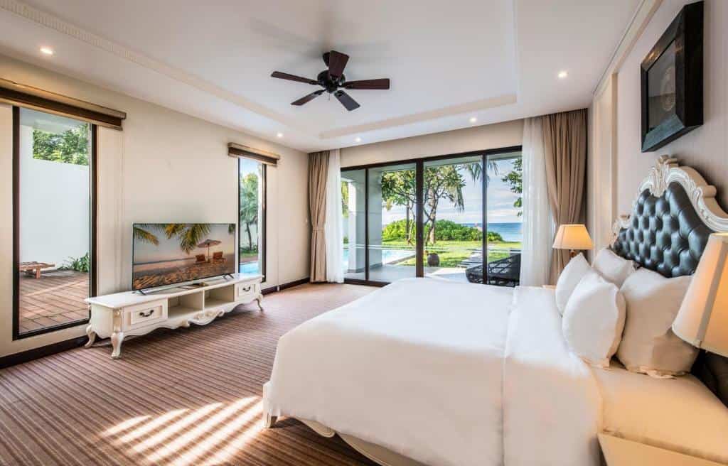 Spacious hotel bedroom with modern design and balcony at Vinpearl Resort & Spa Hoi An.