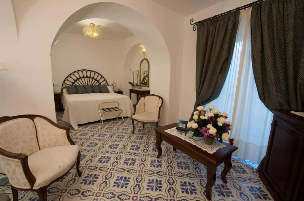 Traditional guest room at Hotel Parsifal in Ravello with patterned tiled floors, arched doorway, and seating area