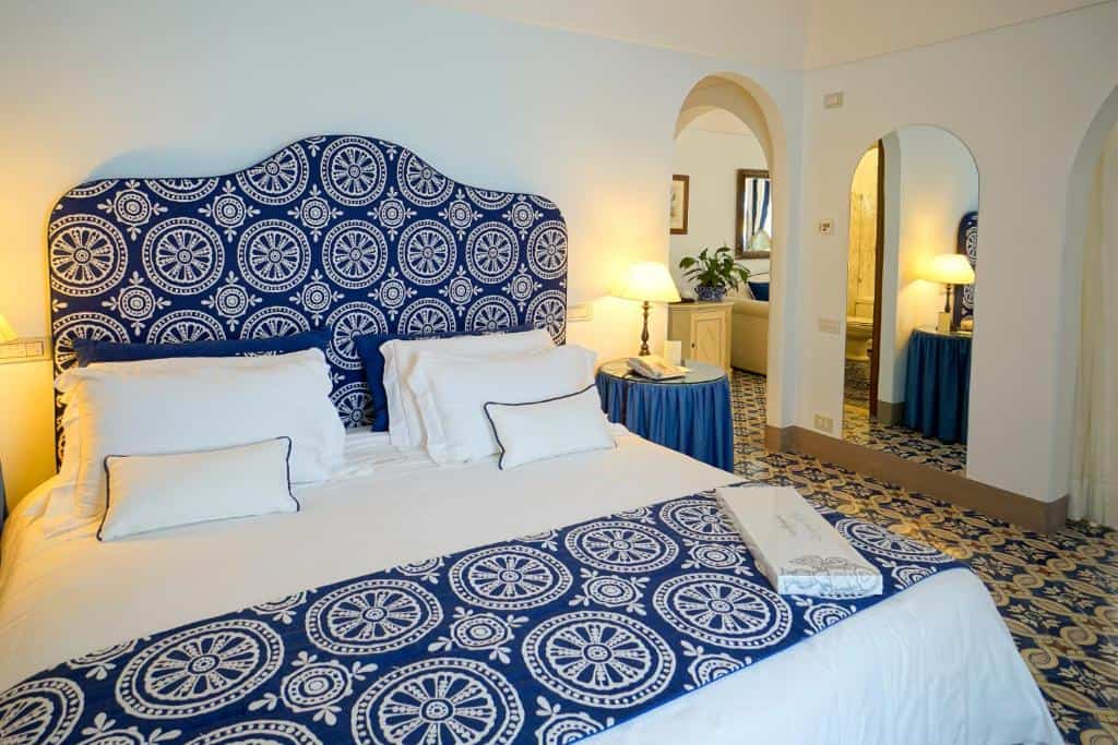 Guest room at Villa Cimbrone in Ravello with patterned tiled floors, blue-and-white textiles, and arched doorways