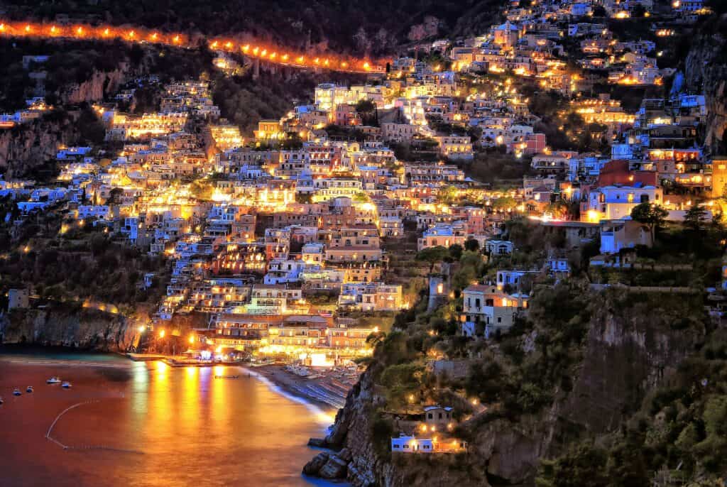 Positano at night with hillside houses glowing above the beach on the Amalfi Coas