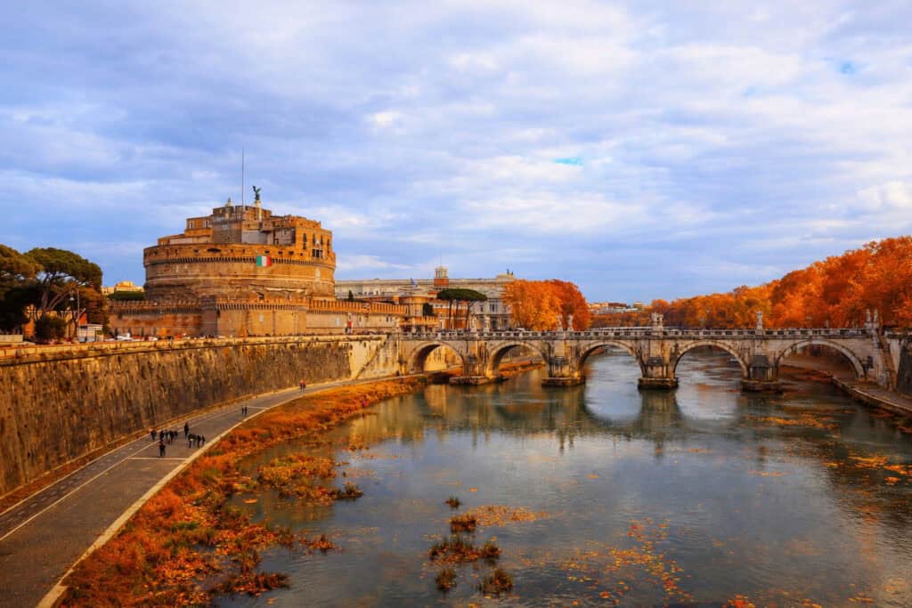 Castel Sant’Angelo and Ponte Sant’Angelo in Rome with autumn trees and red-gold leaves on the Tiber