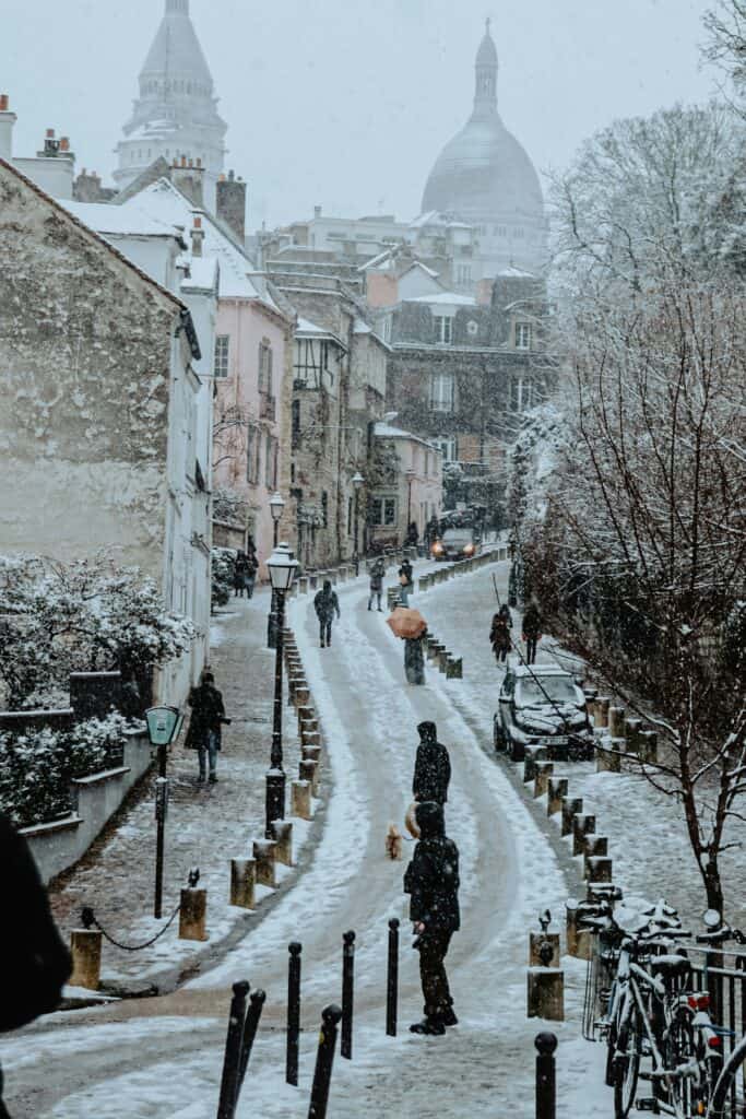 Montmartre street in winter with Sacré-Cœur Basilica rising above the rooftops in Paris
