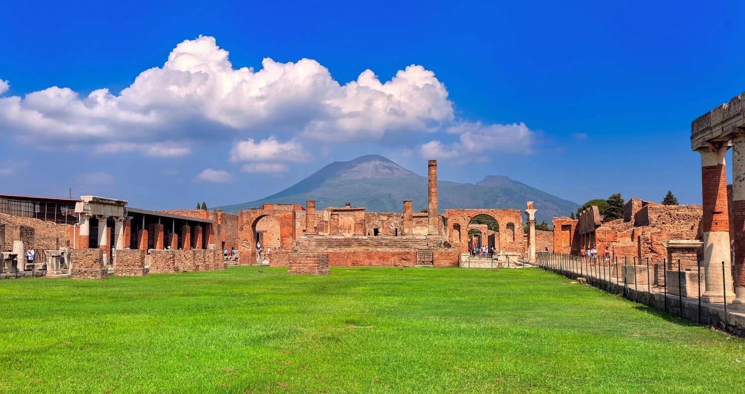 Pompeii archaeological site with Mount Vesuvius in the background, showing ancient Roman streets and ruins