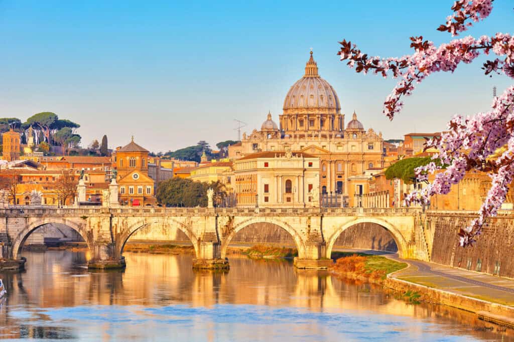 St Peter’s Basilica and bridge over the Tiber River in Rome with spring blossoms