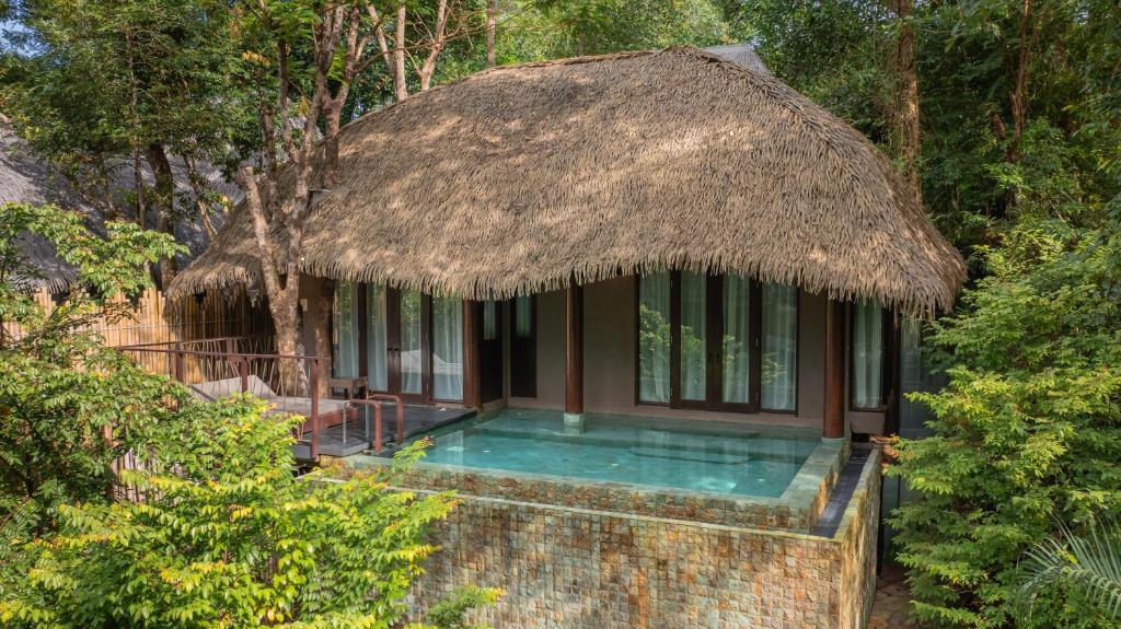 Keemala Phuket jungle pool villa with thatched roof surrounded by tropical rainforest near Kamala Beach